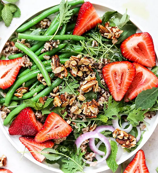 St. Patrick's Day food with a green salad with strawberries and walnuts.