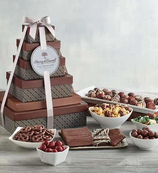 Types of chocolate surrounding a tower of gift boxes.