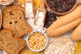 What is gluten with an array of bread, grains, and flour on a counter.