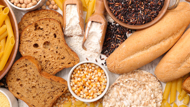 What is gluten with an array of bread, grains, and flour on a counter.