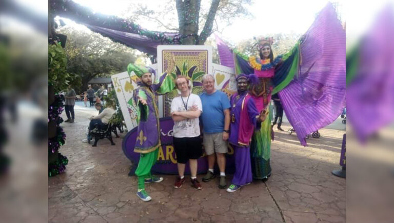 autistic care with a family celebrating Mardi Gras outside at a parade.