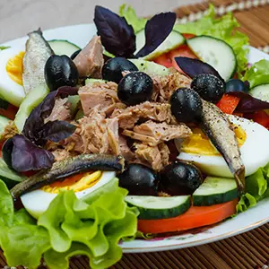 Mesclun niçoise salad on a plate.