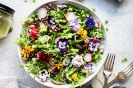 Spring vegetable salad in a bowl with flowers.
