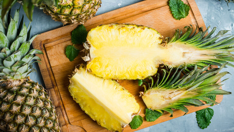 Types of pineapple sliced on a cutting board