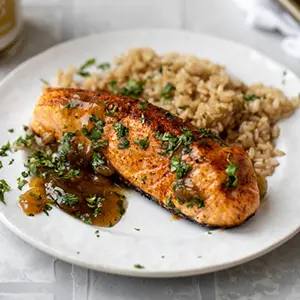 Types of pineapple with a piece of grilled salmon with pineapple relish on a plate with rice.