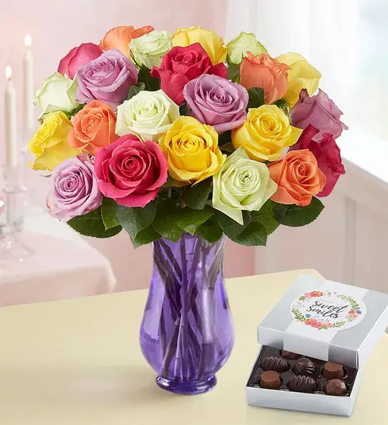 Unique thank you gifts with a bouquet of multi-colored roses next to a box of chocolates.