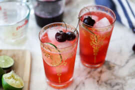 Cherry recipes with two glasses of cherry limeade topped with cherries.