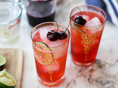 Cherry recipes with two glasses of cherry limeade topped with cherries.