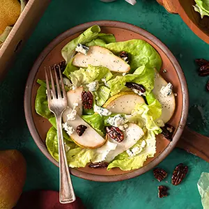 Cherry recipes with a salad with dried cherries and pear slices in a bowl.