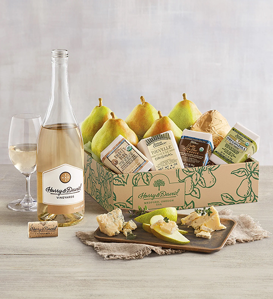 Fruit and cheese pairings with a box of pears and cheese next to a bottle of wine.