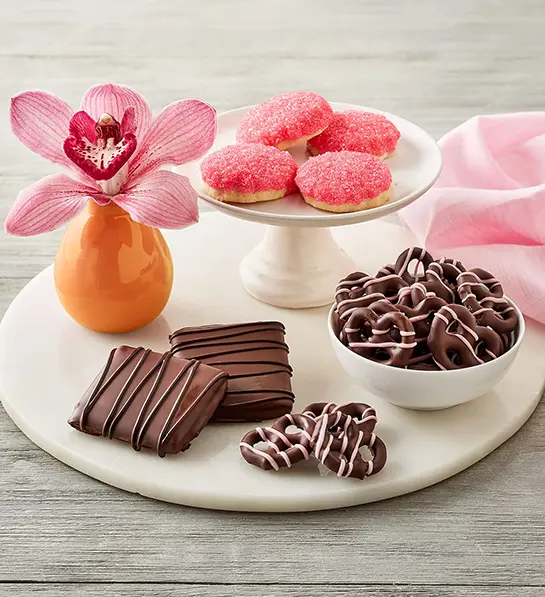 Mother-in-law gifts with a plate of cookies and other chocolate snacks.