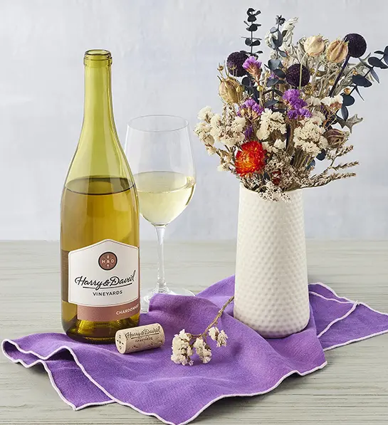 Mother-in-Law gifts with a bouquet of dried flowers next to a bottle of wine.