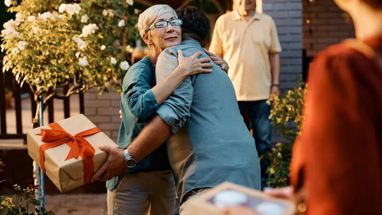 Mother-in-law gifts with a woman hugging a man holding a wrapped gift.