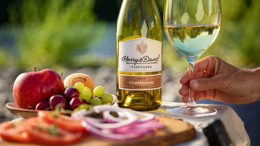 Bottle of Chardonnay next to a table of sliced vegetables.