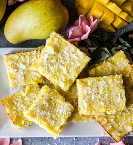 Mango coconut cookie bars stacked on a plate.