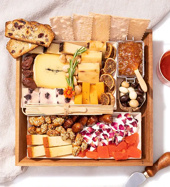 Boarderie charcuterie crate full of cheese, crackers, and other snacks.