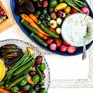 Roasted summer squash and other vegetables on a platter with yogurt dip.