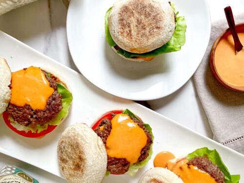 Gourmet burgers with Wolferman's English muffins on a serving tray.