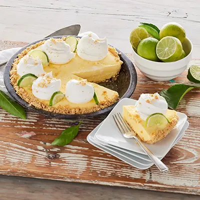 Types of pies with a key lime pie on a wooden board.