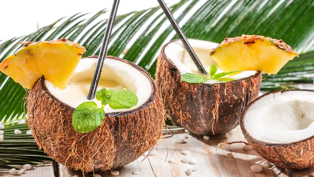 Flavor pairings with coconuts cut in half with slices of pineapple on the edge.