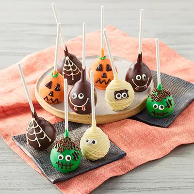 Halloween recipes with several Halloween themed cake pops on a plate.