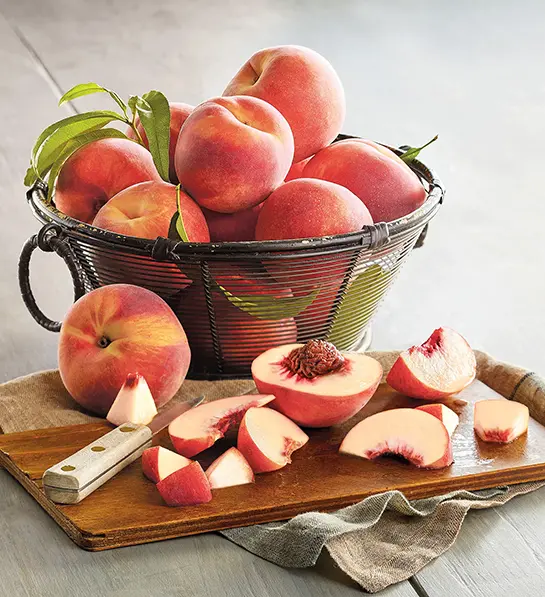 Peppermint peaches in a basket and sliced on a board.
