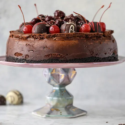 Types of cake with a chocolate cherry cheesecake on a platter.