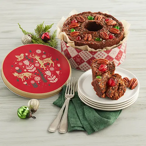 Types of cakes with a fruitcake in a tin with a plate holding a slice of fruitcake next to it.