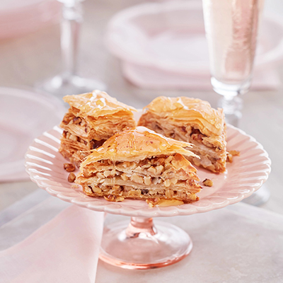 Types of pastries with three slices of baklava on a platter.