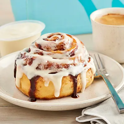 Types of pastries with a cinnamon roll on a plate.