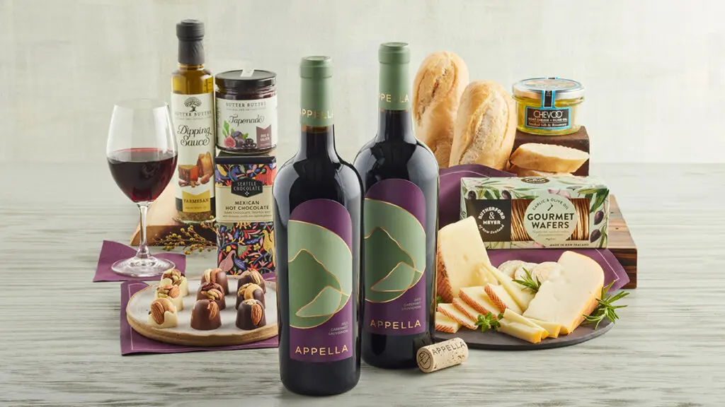 Two bottles of Appella Cabernet Sauvignon with sweet and savory treats behind them.