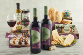 Two bottles of Appella Cabernet Sauvignon with sweet and savory treats behind them.