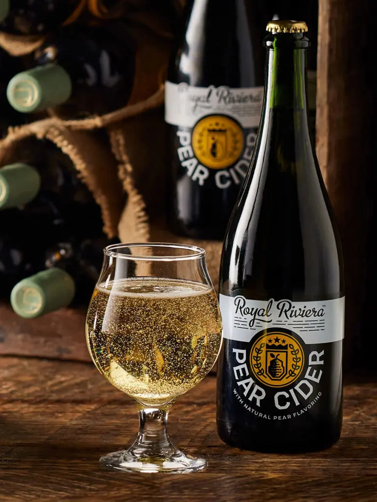 A bottle of Royal Riviera pear cider next to a full glass.