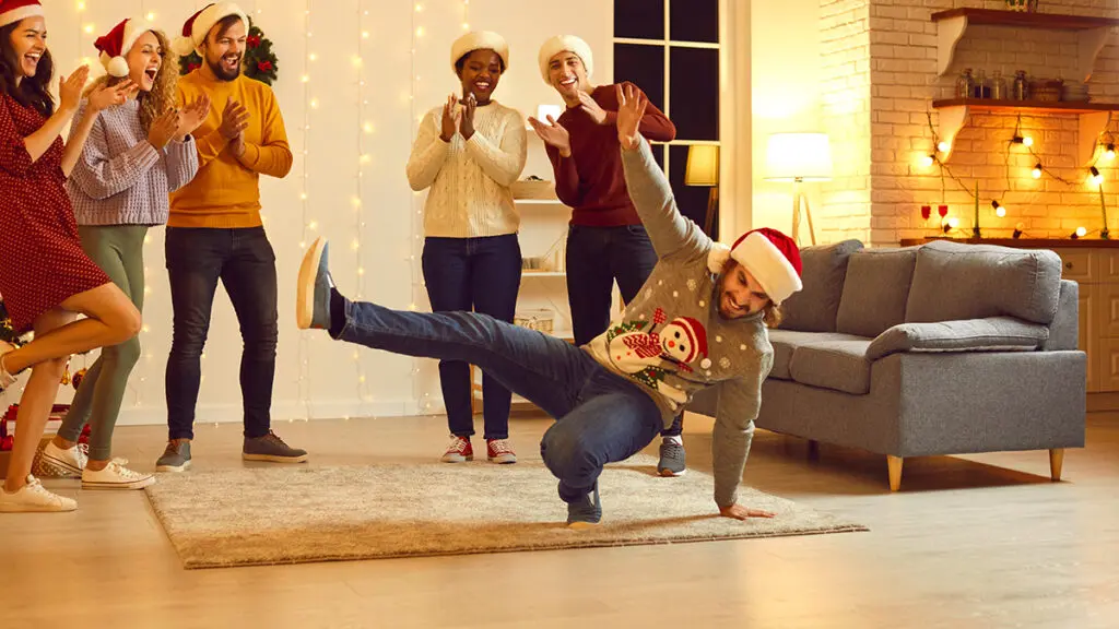 Group of happy young diverse people dancing and having fun at Christmas party at home