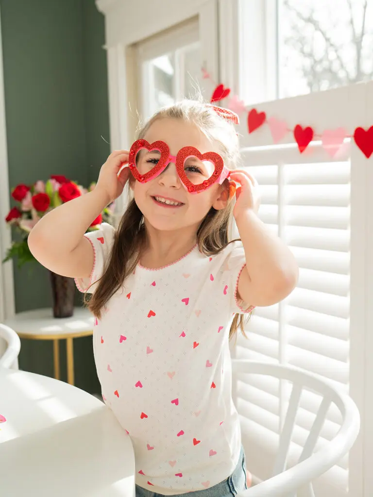 Daughter of Jen Naye Herrmann wearing heart shaped glasses.