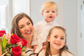 Jen Naye Herrmann with son and daughter and a bouquet of flowers.