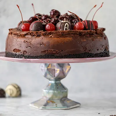Chocolate cherry cheesecake on a platter.