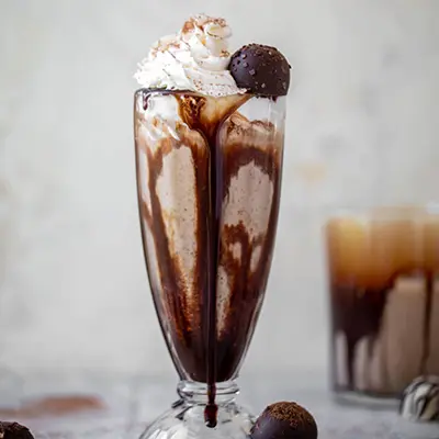 Chocolate truffle milkshake in a tall glass.