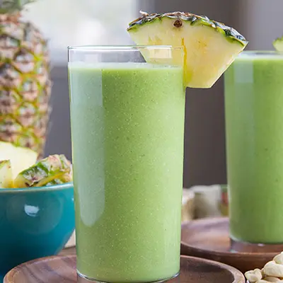 Pineapple recipes with a green smoothie in a glass.