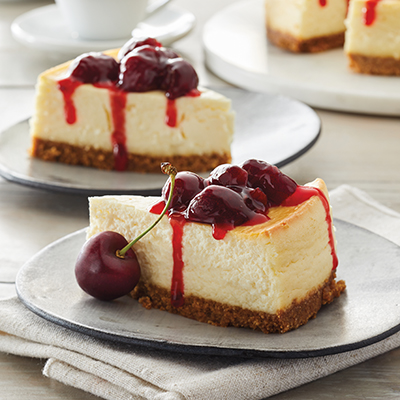 Ways to use fruit with two plates of cheesecake topped with cherrie coulis.