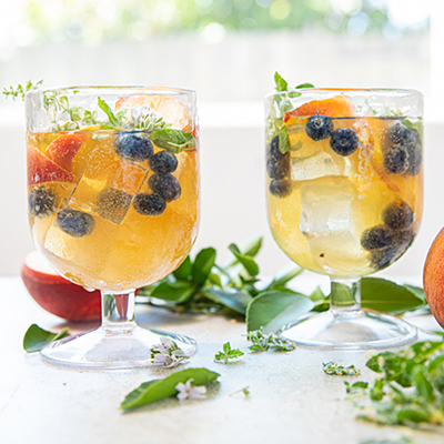 Ways to use fruit with two glasses of peach sangria.